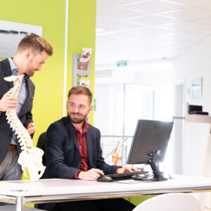 Mitarbeitende beschäftigen sich mit Ergonomie und einem ergonomischen Arbeitsplatz.